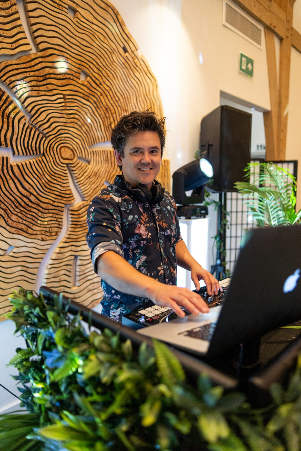 Club Kudo wedding DJ performing at the rustic DJ booth during an evening reception