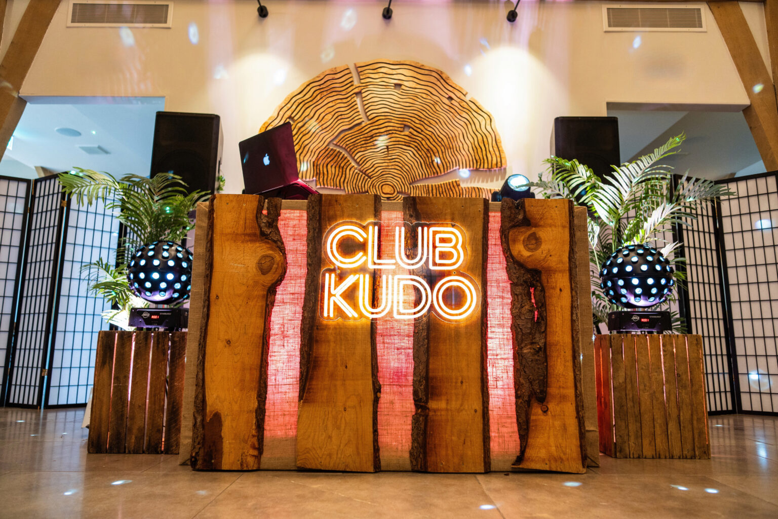 Rustic wooden DJ booth with vintage apple crates and uplighting at a wedding venue