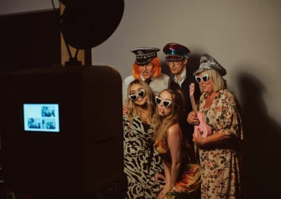 Group of six guests with props at the Club Kudo photo booth