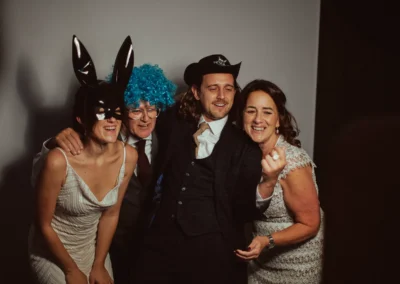 Four guests posing with props at the Club Kudo photo booth